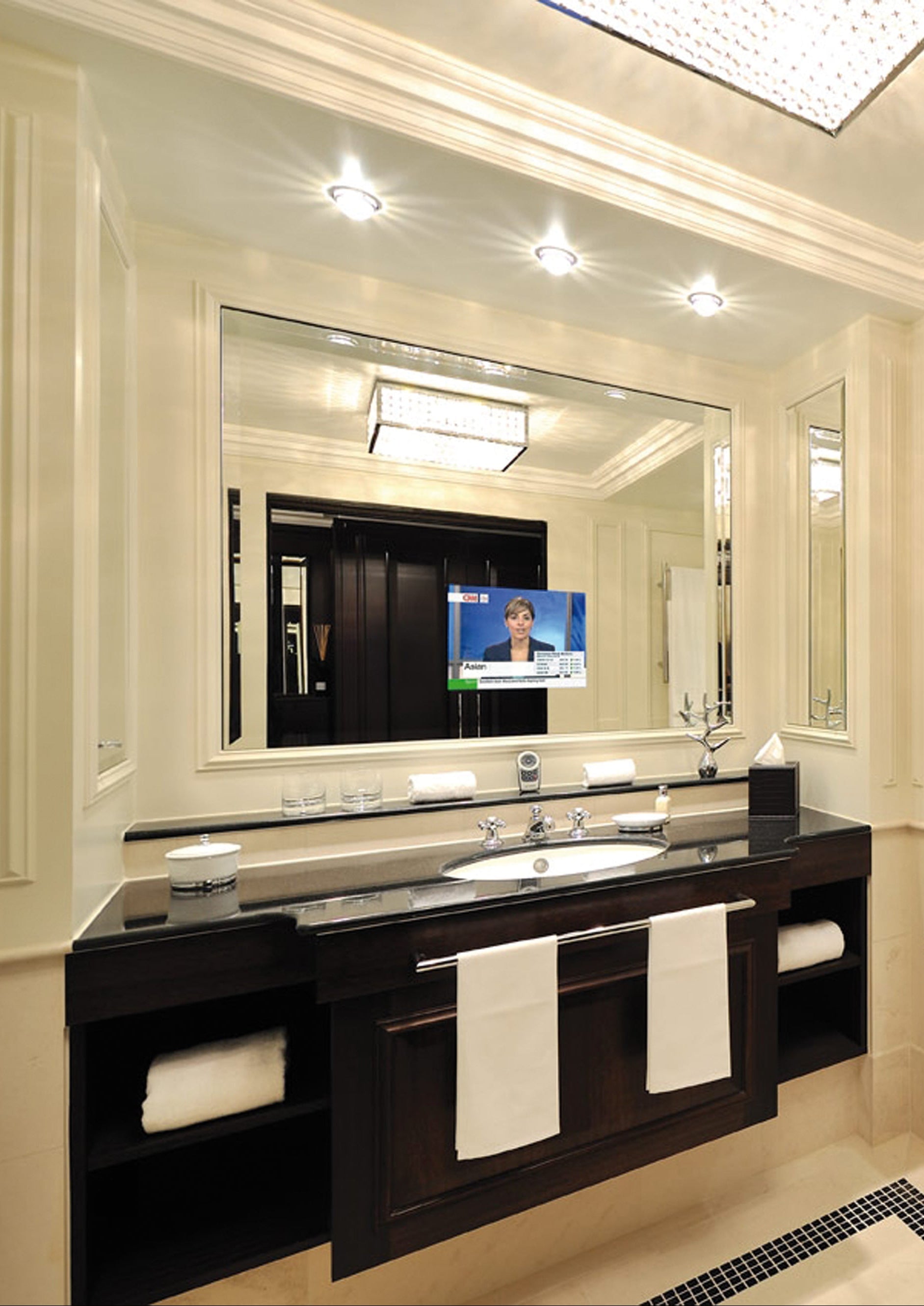 Modern bathroom with bathtub, sink, and mirror TV